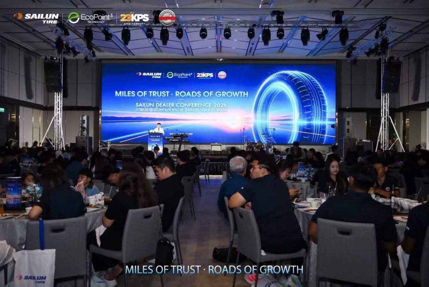 บรรยากาศงานเลี้ยงพร้อมฉากเวที Miles of Trust · Roads of Growth